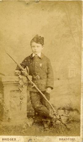 Young Boy leaning against a Pillar