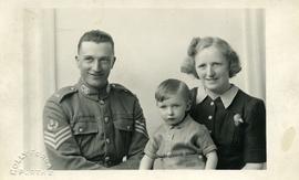 Man in military uniform with woman and child